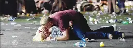  ?? (AFP) ?? A man lies on top of a woman as others flee the Route 91 Harvest country music festival grounds after an active shooter was reported on Oct 1, in Las Vegas, Nevada. A gunman opened fire on a music festival in Las Vegas, leaving at least 58 people dead.