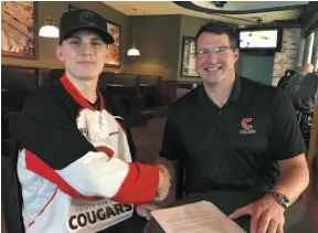  ?? HANDOUT PHOTO ?? Tyson Phare shakes hands with Prince George Cougars general manager Todd Harkins. Phare has signed a player agreement with the Cats.