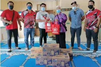  ??  ?? Fairuz (third left) presenting a donation to a representa­tive from Kampung Wani mosque.