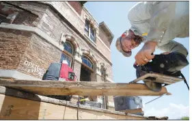  ??  ?? Jacob Kartchner trims a piece of lumber while helping repair the boardwalks around the saloon at the Mescal Movie Set.