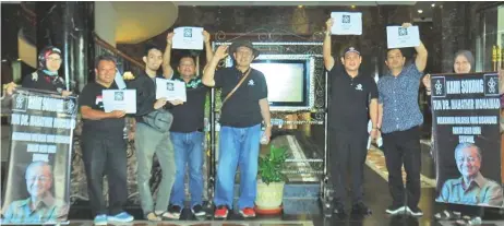  ??  ?? Didi (third right) and other Blackout Bersatu Sarawak members hold up the ‘blacked-out’ version of the Bersatu party logo, in support of Dr Mahathir.