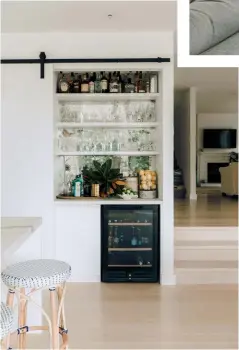  ??  ?? DRINKS, ANYONE? The stylish bar, complete with aged mirrored glass which Kate cleverly made, can be discreetly concealed behind a custom barn slider. A large geometric floor rug in the living space defines the lounge zone in this open-plan layout.