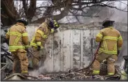  ?? ?? Fire officials from Lubbock, Texas, help put out smoldering debris of a home destroyed by the Smokehouse Creek fire on Thursday in Stinnett, Texas.