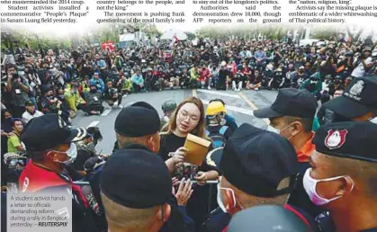  ??  ?? A student activist hands a letter to officials demanding reform during a rally in Bangkok yesterday. – REUTERSPIX