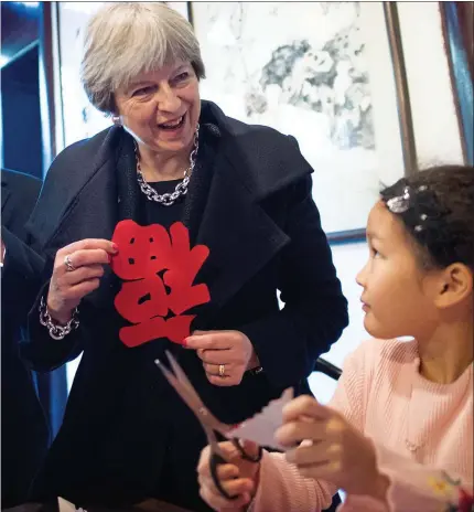  ??  ?? Philip hold cutouts of the Chinese character for “luck” upside down on a visit to the Yu Yuan Temple Garden in Shanghai today