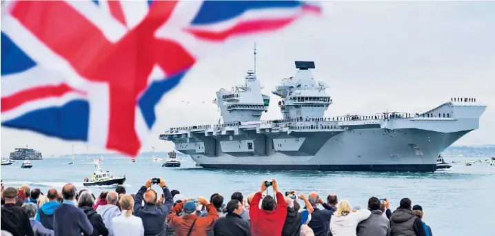  ??  ?? Thousands flew the flag and welcomed HMS Queen Elizabeth, the Royal Navy’s new aircraft carrier, as it arrived at its home port of Portsmouth. Costing £3 billion, it is the Navy’s largest ever warship. The First Sea Lord said it embodied Britain’s...