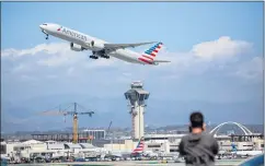  ?? PHOTO BY CHUCK BENNETT ?? Nice weather brought out plane spotters on Tuesday afternoon at LAX as one takes photos of an American Airlines jet taking off.