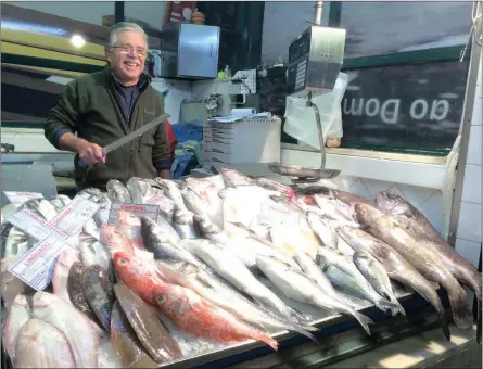  ?? Picture: THE WASHINGTON POST. ?? CATCH OF THE DAY: A fishmonger in the Mercado da Ribeira shows off his morning inventory in Lisbon.