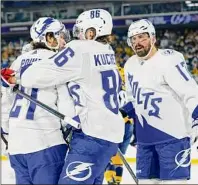  ?? Mark Humphrey / Associated Press ?? Tampa Bay Lightning center Brayden Point, left, is congratula­ted by Nikita Kucherov, center, after Point scored a goal against the Nashville Predators in the second period of an NHL Stadium Series game Saturday.