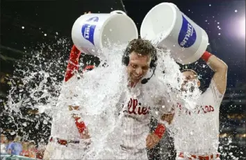  ?? Tim Nwachukwu/Getty Images ?? Phillies first baseeman Rhys Hoskins receives a water shower from teammates after his walkoff double Monday in Philadelph­ia.