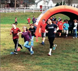  ??  ?? Fourth-grade teacher Mary Ann Bruce runs with fourth-grade students in the APEX Fun Run.