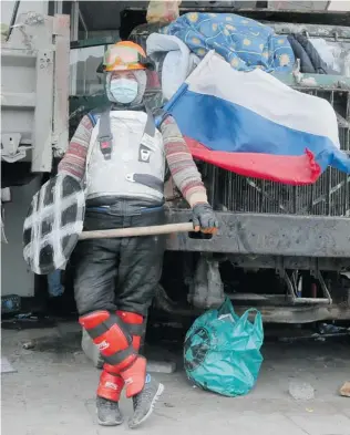  ?? EFREM LUKATSKY/ THE ASSOCIATED PRESS ?? A pro- Russian activist guards a regional administra­tion building that has become a hotbed of resentment against the perceived chauvinist Ukrainian nationalis­m among the nation’s leadership.