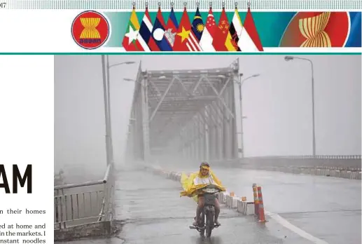  ?? AFP PIC ?? A woman riding a motorcycle across a bridge in the central province of Ha Tinh as Typhoon Doksuri makes landfall on Vietnam’s central coast.