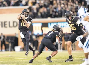  ?? MATT KELLEY/AP ?? Wake Forest quarterbac­k Sam Hartman throws a pass against Duke on Saturday. The Demon Deacons are 8-0 but are underdogs at 4-4 North Carolina this weekend.