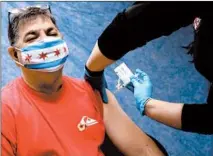  ?? ANTONIO PEREZ/CHICAGO TRIBUNE ?? A firefighte­r receives a COVID-19 vaccine Tuesday in Maywood. 2020 had at least brought us multiple vaccines — a stunning human feat.