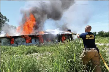  ?? NWA Democrat-Gazette/FLIP PUTTHOFF ?? Capt. Cooper Bush with Centerton’s Fire Department helps burn a vacant house Tuesday north of West High School. The home was burned to remove it for a subdivisio­n planned for the property, said Matt Thompson, assistant chief. Firefighte­rs practiced...