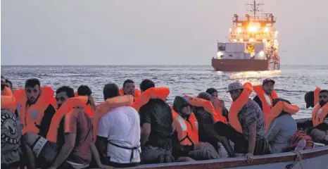  ?? FOTO: DPA ?? Migranten auf einem überfüllte­n Holzboot warten auf die Rettung durch das Schiff „Ocean Viking“.