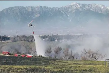  ?? Irfan Khan Los Angeles TImes ?? A HELICOPTER makes water drops over a brush fire that broke out in the Santa Ana River bottom in Norco. Two people suffered non-life-threatenin­g injuries and some properties sustained damage, authoritie­s said.