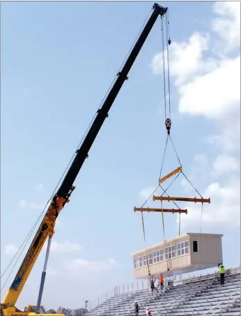  ?? Times photograph by Annette Beard ?? After nearly two hours of preparatio­n of the crane Friday morning, the press box was lifted into place atop the 1,600-seat bleachers on the west side of the new Blackhawk Stadium.