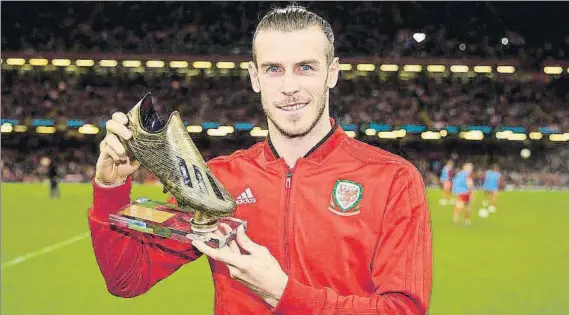  ?? FOTO: TWITTER ?? Bale recibió una bota de oro por convertirs­e en el máximo goleador de la historia de Gales (30 tantos) Recibió el premio durante el descanso del amistoso de España en Cardiff