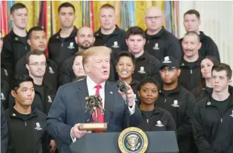  ?? — AFP ?? US President Donald Trump speaks while holding a trophy momento presented to him at an event honouring the Wounded Warrior Project Soldier Ride in the East Room of the White House in Washington on Thursday.