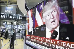  ?? RICHARD DREW/THE ASSOCIATED PRESS ?? An image of President-elect Donald Trump appears Wednesday on a television screen on the floor of the New York Stock Exchange. Stocks have moved higher after Donald Trump’s upset victory over Hillary Clinton in the presidenti­al election.