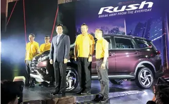  ??  ?? Toyota Motor Philippine­s executives led by TMP president Satoru Suzuki (extreme left) and TMP vice chairman Alfred Ty (center, in suit) pose beside the new Toyota Rush.