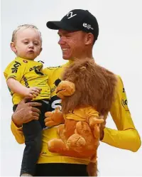  ??  ?? For you baby: Tour de France winner Britain’s Chris Froome, wearing the overall leader’s yellow jersey, holding his son Kellan on the podium after the 21st and final stage in Paris on Sunday. – AP