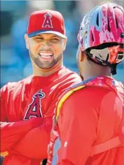  ?? Gary Coronado Los Angeles Times ?? ALBERT PUJOLS, chatting with Angels catcher Martin Maldonado, is hitting .323 this spring.