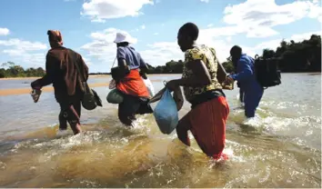  ?? (File pic) ?? Zimbabwean­s wade across the Limpopo River on their way to South Africa.