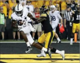  ?? JEFF ROBERSON — THE ASSOCIATED PRESS ?? Penn State wide receiver Juwan Johnson, left, catches a TD pass as Iowa defensive back Manny Rugamba defends as time expires Saturday in Iowa City, Iowa. Penn State won, 21-19.