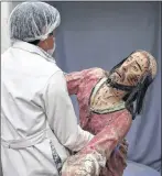  ?? MARTIN MEJIA/THE ASSOCIATED PRESS ?? An art restorer carries a damaged sculpture of Jesus Christ to be restored at the Ministry of Culture’s Restoratio­n Center in Cuzco, March 1, 2018. The team also restores delicate sculptures depicting Catholic martyrs made from wood and cloth which are often missing heads or arms.