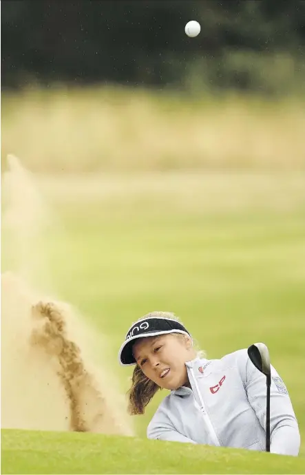  ?? ROSS KINNAIRD/GETTY IMAGES ?? Brooke Henderson of Smiths Falls, Ont., blasts out of the bunker on her way to a 2-under 70 during Friday’s second round at the Women’s British Open in Lytham St Annes, England. Henderson sits in a tie for eighth at 5 under, while Thailand’s Pornanong...