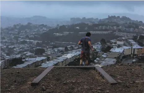  ?? Yalonda M. James / The Chronicle 2020 ?? A runner goes down steps on Twin Peaks during the rain and blistery wind on Nov. 13, 2020.