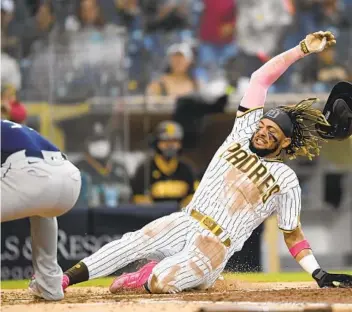  ?? DENIS POROY GETTY IMAGES ?? Fernando Tatis Jr. scores from first on Eric Hosmer’s single and an error by the Mariners in the fifth inning.