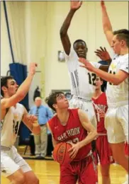 ?? TANIA BARRICKLO — DAILY FREEMAN ?? Red Hook’s Jason Davis keeps eye on the basket as he is surrounded by Highland’s Cameron Ness, Tyler Benjamin, and Sean Benkert.