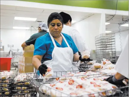  ?? Erik Verduzco ?? Las Vegas Review-journal @Erik_verduzco Maria Martinez organizes packaged hot dogs Aug. 21 at the Clark County School District Food Services Department central building.