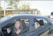  ?? GREGORY BULL — THE ASSOCIATED PRESS ?? Brooklyn Pittman talks as she sits in her car with her dogs after receiving food from an Armed Services YMCA food distributi­on in San Diego.