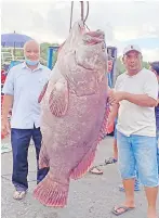  ??  ?? Rahman (right) and the owner of the fishing vessel pose for a picture with the giant grouper.