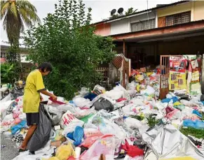  ?? — Bernama ?? What a difference: Chung cleaning the compound of her house after the inspection in Taman Bersatu, Simpang Pulai. ( Top) Chung was seen sorting the clutter at her home last week.