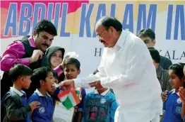 ?? — PTI ?? Vice-president Venkaiah Naidu offers cake to children during a function organised in front of India Gate in New Delhi on Sunday to mark the 86th birthday anniversar­y of former President A.P.J. Abdul Kalam.