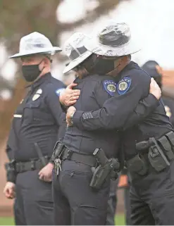  ?? MEG POTTER/THE REPUBLIC ?? Two of ASU police Officer Joseph Montgomery’s colleagues embrace each other after Montgomery’s memorial service at the LDS Institute on ASU’s Polytechni­c campus on Friday. Montgomery was with the ASU police force for 13 years.
