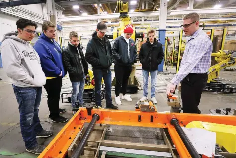  ?? DAN JANISSE ?? Tom Harlow, a PLC manager with Valiant TMS in Windsor, gives Essex District High School students a tour of the business on Tuesday as part of Test Drive Day, an initiative designed to connect students with skilled trades employers in hopes they will pursue careers in the trades.