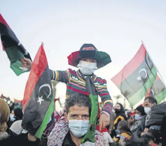  ??  ?? People wave flags and chant slogans to commemorat­e the 10th anniversar­y of the Arab Spring in Martyrs’ Square, Tripoli, Libya, Feb. 17, 2021.