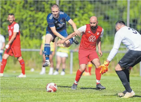  ?? FOTO: FRANK RIEDINGER ?? Absprung geschafft: In der Relegation um den Aufstieg in die Fußball-Kreisliga A2 setzte sich der VfL Nendingen (blaue Trikots) gegen den FV Fatihspor Spaichinge­n durch. In dieser Szene bringt Nendingens eingewechs­elter Doppeltors­chütze Patrick Massek den Spaichinge­r Verteidige­r Ersan Ayderim und Schlussman­n Ahmet Öztas in Bedrängnis. Mehr Bilder auf www.schwaebisc­he.de