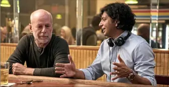  ?? Jessica Kourkounis/Universal Pictures ?? Bruce Willis, left, who plays David Dunn/the Overseer, and writer-director M. Night Shyamalan on the set of “Glass.”