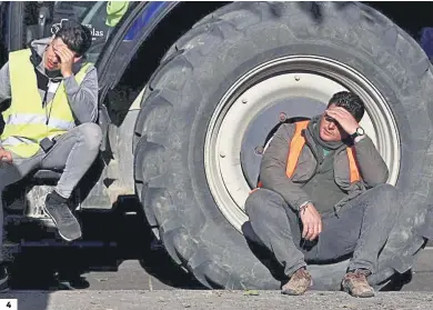  ?? JAVIER ALBIÑANA ?? 4 4. Manifestan­tes descansan en la rueda de un tractor.