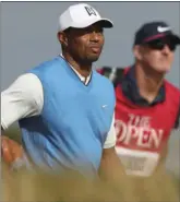  ??  ?? Tiger Woods of the US and his caddie Joe Lacava walk along the seventh fairway during the first round of the British Open Golf Championsh­ip in Carnoustie, Scotland, Thursday.
AP PHOTO/JON SUPER
