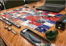  ?? CONTRIBUTE­D ?? Four skimming suspects were found with three laptops, a magnetic stripe credit card encoder and more than 400 counterfei­t credit cards, according to court documents.