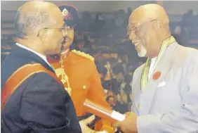  ?? ?? Maurice Foster (right) accepts the National Honour, Order of Distinctio­n (OD), Commander Class from then Governor General Sir Kenneth Hall.